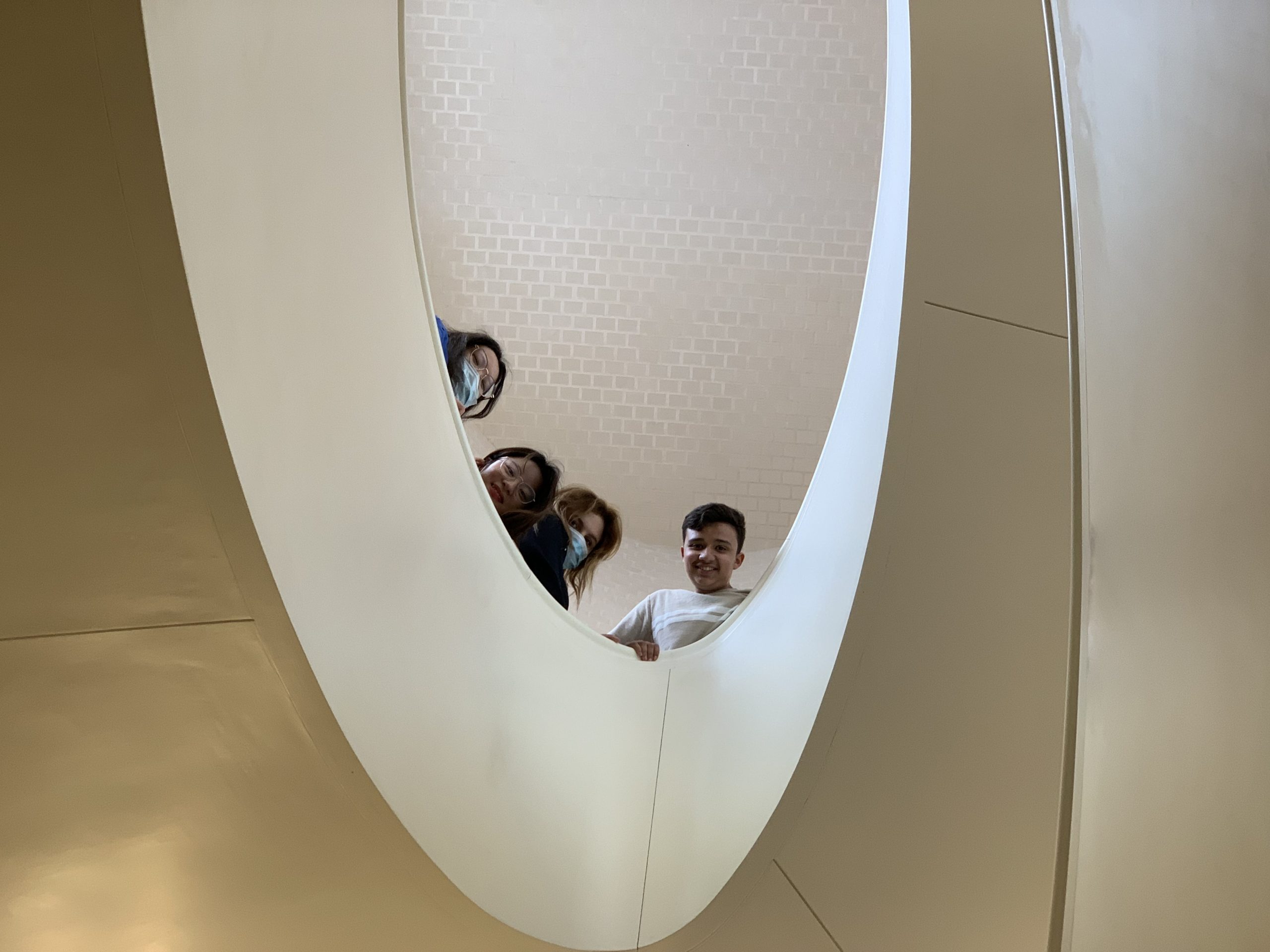4 students looking down from the staircase