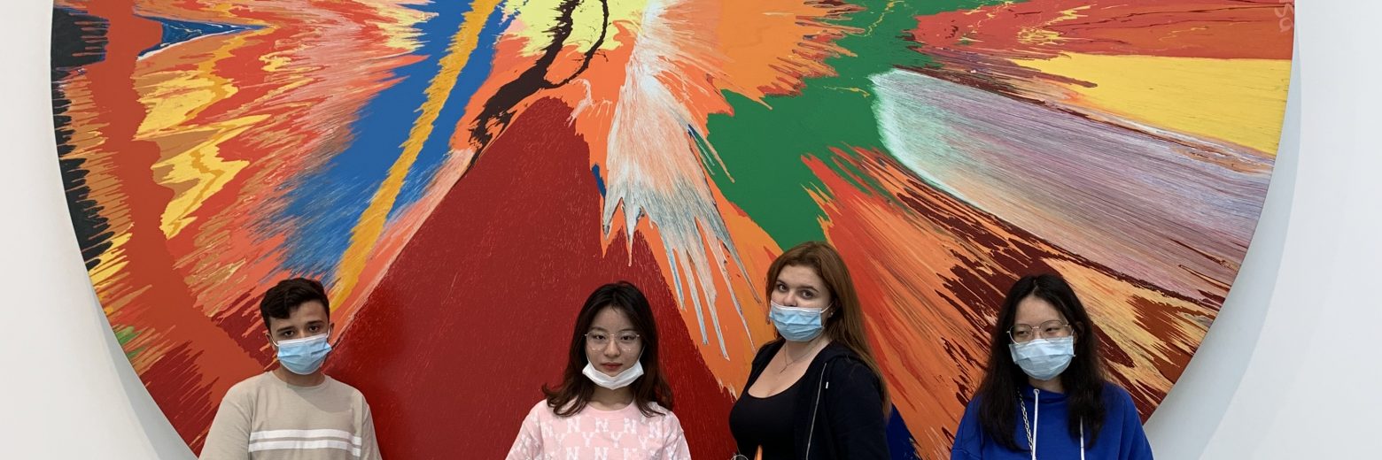 student stood with the painting in the background