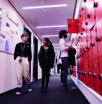 students walking through corridor in front of lockers