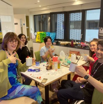 students holding mug cakes